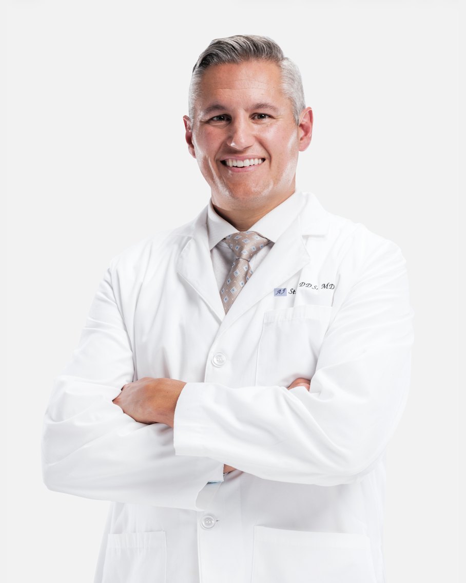 Dr. AJ Stosich, DDS · MD, in a white coat